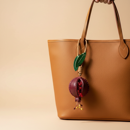Bijou de Sac Grenade Verger présenté sur un sac caramel